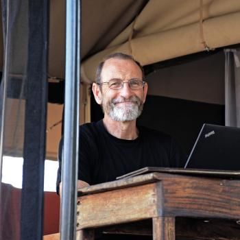 Photo of Chris Field, at his laptop, smiling