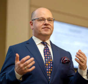 Photo of Mark Lemley, blue blazer, colorful tie speaking to audience